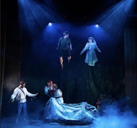 a group of people on stage in a dark room