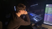 a young man sitting in front of a computer screen