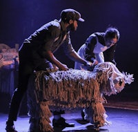 a man and a woman on stage with a large stuffed animal