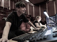 two people sitting in front of a computer in an auditorium